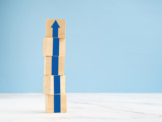 Common goal success concept. Arrow up on wooden cubes with a blue background