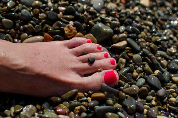 wet foot of a girl on a rocky beach