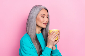 Photo of gorgeous satisfied person closed eyes hold smell fresh coffee isolated on pink color...