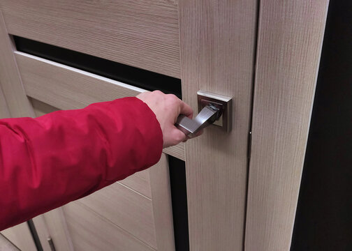 woman opens or closes door with her hand on handle