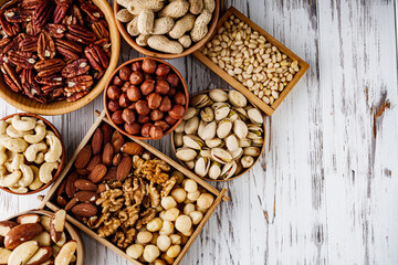 set of different nuts on a white wooden rustic background