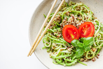 zucchini noodles with quinoa on a white background