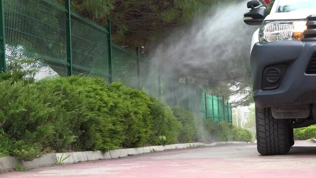 Pest control concept. Car sprays insecticides from sprayer on back.