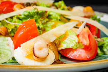 fresh tasty salad with seafood on a black background