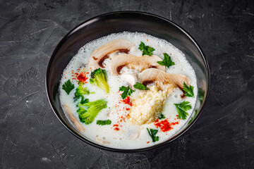 creamy mushroom soup with champignons on a black background