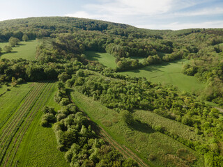 aerial drone flight over green meadows and forest in lower austria