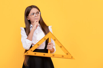 pondering kid in school uniform and glasses hold mathematics triangle for measuring, measurement