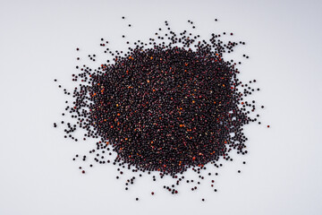 black quinoa seeds on a white acrylic background