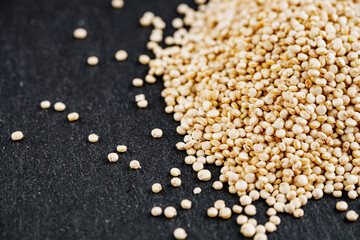 white quinoa seeds on a dark rustic background