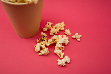 Popcorn in a cup on a bright pink background