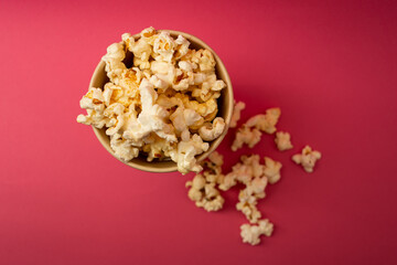 Popcorn in a cup on a bright pink background