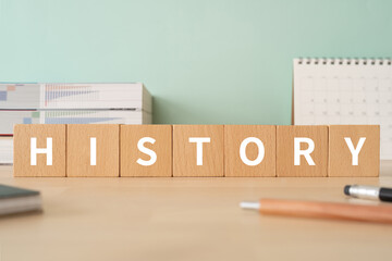 歴史のイメージ｜「HISTORY」と書かれた積み木が置かれたデスク
