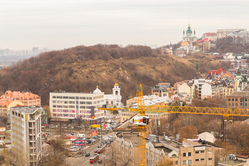 Naklejka premium Ukraine, Kyiv – November 26, 2016: Aerial panoramic view on central and historical part of Kyiv city, residential area in the evening. St Andrew's Church, Podil area.