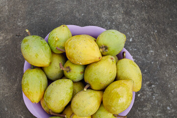 Fresh canistel fruit in a plastic bowl