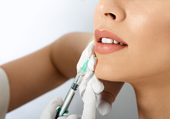 Lips filler injection for beautiful woman's lip augmentation, close-up. Lip augmentation procedure...