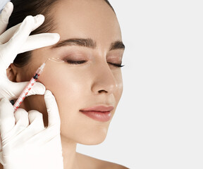 Woman receives anti wrinkle beauty injection for facial rejuvenation and wrinkle removal. Facial...