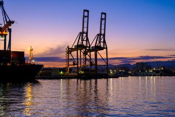 Obraz premium Cranes in Harbor during Sunset