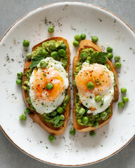 Toasts with green peas and eggs on a concrete background. Homemade healthy pea toast