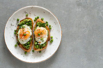 Toasts with green peas and eggs on a concrete background. Homemade healthy pea toast