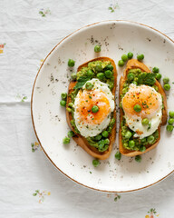 Toasts with green peas and eggs on a concrete background. Homemade healthy pea toast