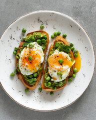 Toasts with green peas and eggs on a concrete background. Homemade healthy pea toast
