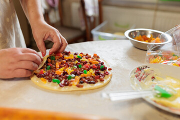 female hands twist the dough with raisins and candied fruits. raw cake dough