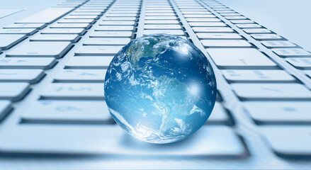 Glass globe on blured laptop keyboard 