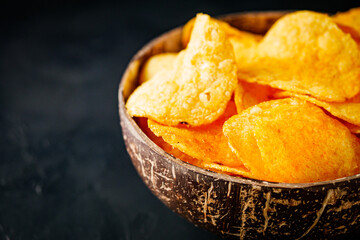 golden crispy potato chips on a dark background