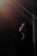 portrait of caucasian girl isolated on dark background with rays and space dust. Beautiful dreamy model in imaginary space. The concept of human emotions, mystery, fairy-tale universe, fashion.