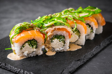 delicious sushi rolls on a black stone background