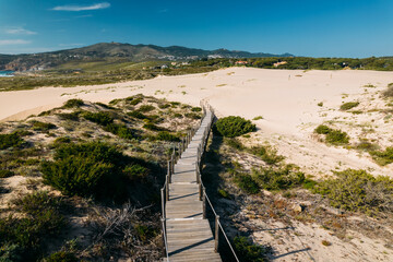 Aerial drone view of pedestrian path to Guincho Beach in Cascais, Portugal next to sand dunes - obrazy, fototapety, plakaty
