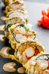 delicious sushi rolls on a black stone background