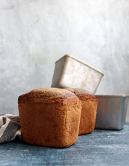 Rectangular bread and aluminum forms on a table. Freshly homemade baked rye bread close up photo. 