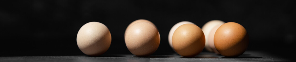 Top view of organic chicken eggs on top of dark wooden background.