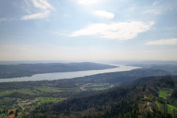 Panoramic view from local mountain Uetliberg with Lake Zürich and Swiss Alps in the background on a blue cloudy spring day. Photo taken April 14th, 2022, Zurich, Switzerland.