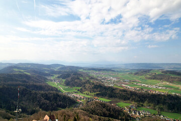 Fototapeta na wymiar Aerial view of valley with forest and agricultural fields seen from local mountain Uetliberg on a blue cloudy spring day. Photo taken April 14th, 2022, Zurich, Switzerland.