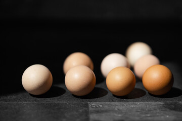 Top view of organic chicken eggs on top of dark wooden background.