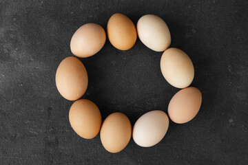 Organic chicken eggs on dark wooden background with copy space.