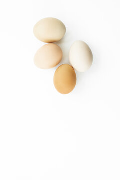 Four eggs out of egg tray isolated on white background. Eggs protected in brown recycle paper tray at ease of use and handle. Top view image with copy space.