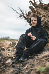 A boy walks among cut down trees. Russia.