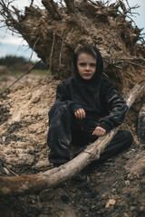 A boy walks among cut down trees. Russia.