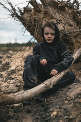 A boy walks among cut down trees. Russia.