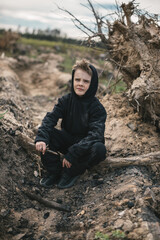 A boy walks among cut down trees. Russia.