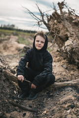 A boy walks among cut down trees. Russia.