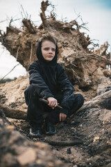 A boy walks among cut down trees. Russia.