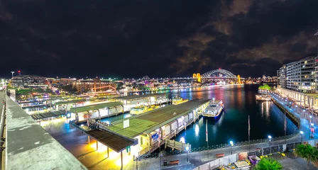 Fototapeten Panoramic night view of Sydney Harbour and CBD buildings on the foreshore in NSW Australia © Elias Bitar