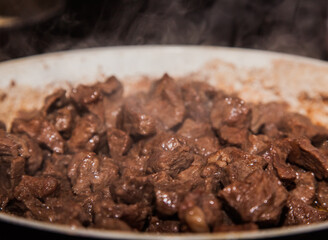 Sliced beef meat fried in a pan close-up.