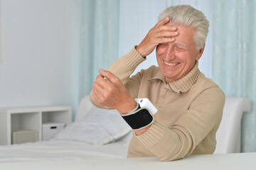 Senior man using automatic carpal tonometer in hospital
