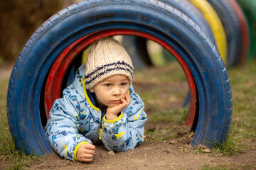 Sweet preschool child, cute boy, playing on the playground in the park, spring
