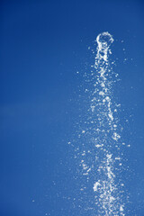 Naklejka na ściany i meble Water splashing from the fountain in the background of blue sky